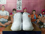 Front view of the white high-top basketball shoes showing textured uppers and light-colored outsoles.