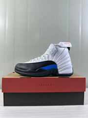 Side view of a white, black, and blue Air Jordan 12 sneaker displayed on a Jordan shoe box.