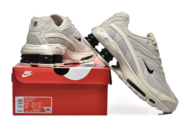 Cream and grey Nike Shox Ride 2 sneakers shown with a red shoe box; the box label shows sample sizes 8.5 and 10.