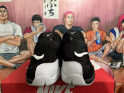 Front view of black and white high-top Nike basketball sneakers with zip-front uppers and visible Swoosh logos.