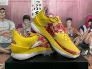 Angled side view showing the yellow floral-print basketball shoes and FLOW midsole marking