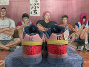 Rear view of pink Nike sneakers showing dark gray collars, red patterned heel panels, yellow-green heel accents, and the number 12.
