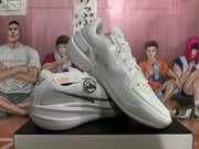 White Nike basketball shoes shown from side and angled views, highlighting mesh-patterned panels and heel details.