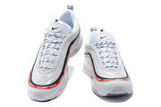 Pair of white Nike Air Max 97 sneakers viewed from above and the front, with red and green UNDEFEATED trim.