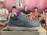 Side profile of a smoke gray low-top sneaker showing the tonal Nike swoosh, layered panels and textured sole.