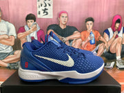 Side profile of a blue Nike basketball shoe showing the textured upper, white Swoosh, white midsole, blue outsole, and red number 8 detail.