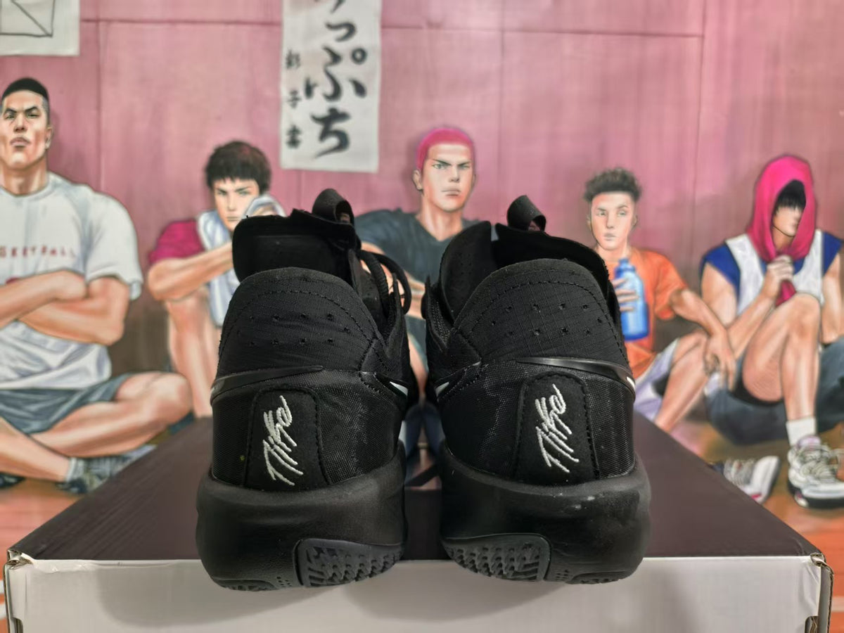 Rear view of black Nike sneakers showing heel branding and textured black outsoles.
