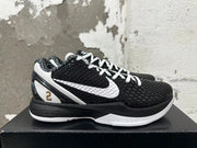 Side view of a black and white Nike basketball shoe with a white Swoosh and gold-toned number 2 detail