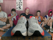 Front view of white and gray Brooks Hyperion Max running shoes with orange-red details