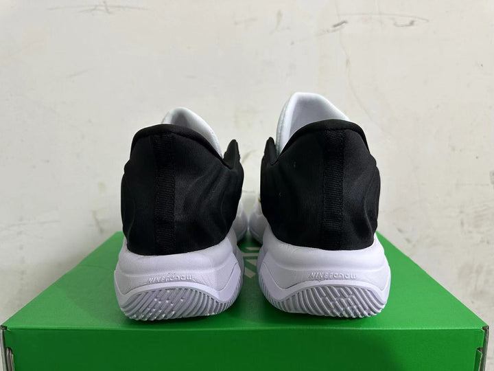 Rear view of white Nike basketball shoes with black heel panels and white outsoles