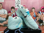 Pale blue and white Nike basketball shoes with bright blue laces, shown at an angle.