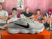 Side view of a gray Nike sneaker displaying the black Swoosh and layered white sole.
