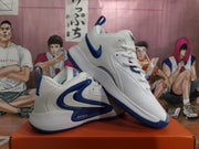 Angled view showing the white and blue Nike sneakers, padded collars, laces, and textured outsole edges.