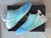 Angled side view of the paired sneakers showing the translucent outsole and blue toe panels.
