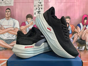 Pair of black Brooks running shoes with white sculpted midsoles and red accents, shown at an angle.