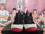 Front view of black, white, and red basketball sneakers with black laces and red outsole accents.