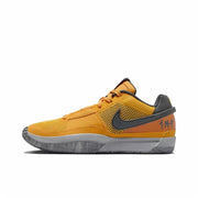 Gold and black low-top basketball sneaker with an orange heel panel and gray outsole.