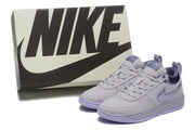 Purple Nike sneakers displayed beside a Nike shoe box.