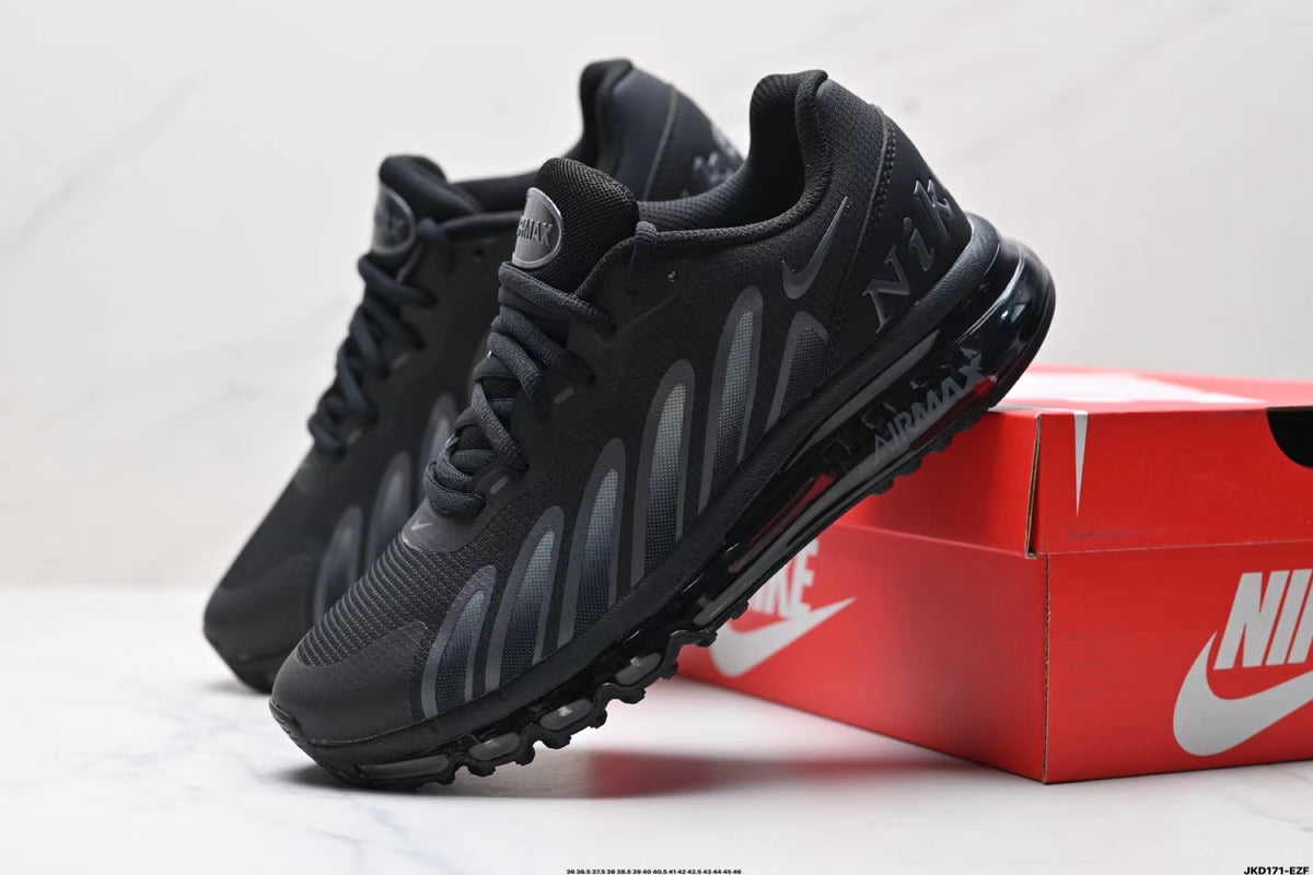 Black Nike Air Max sneakers with dark grey side details beside a red Nike shoe box