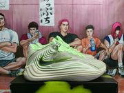 Side profile of a pale Nike basketball shoe with a dark Swoosh outlined in lime.