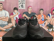 Front view of black lace-up basketball shoes with red tongue accents.