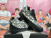 Angled view highlighting the leopard-print upper, black outsole, and side star-and-chevron mark.