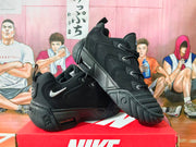 Side view of black Nike sneakers showing the layered panels, contrasting Swoosh, and sculpted sole.