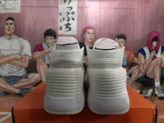Rear view of a pair of white and silver Nike high-top basketball sneakers on an orange shoebox.