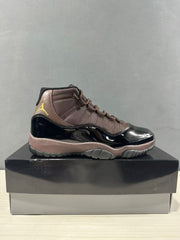 Side profile of the black and bronze high-top sneaker on a black shoebox.