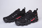 Pair of black and red sneakers shown from a front-side angle.