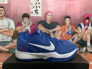 Side view of a blue Nike basketball sneaker showing the textured upper, white Swoosh, red number 8 and white midsole.
