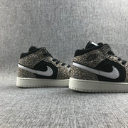Pair of leopard-print and black mid-top sneakers shown from the side.