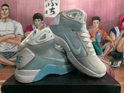 Angled view of the pair of white and light blue Nike high-top basketball sneakers showing the side panels, heel details and blue outsole accents.