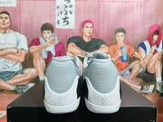 Rear view showing the gray heel panels, white speckled sections, black accents, and heel emblem.