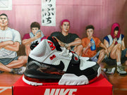 Side view showing perforated panels, a black midfoot strap, patterned overlays, and heel Air unit.