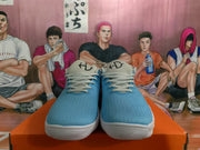 Front view of blue Nike low-top sneakers with light laces, padded tongues, and white outsoles.