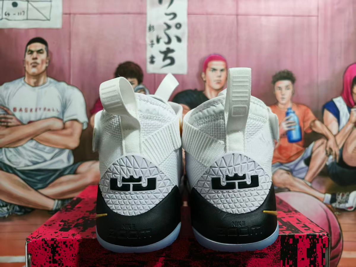 Rear view of white and black Nike LeBron basketball shoes with heel logos and translucent blue-tinted outsoles.
