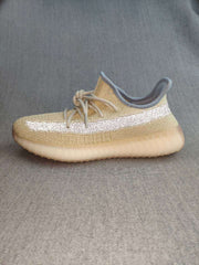 Profile view of the beige sneaker with light gray collar trim and translucent sole.