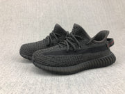 Pair of black sneakers shown from a three-quarter angle with matching ribbed soles.