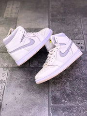 Pair of pearl white high-top sneakers arranged on a tiled surface, showing both outer sides and pale pink outsoles.