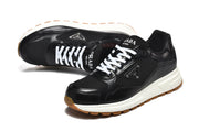 Angled top view of black lace-up sneakers with white laces, branded tongues, and triangular side plaques.