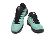 Pair of green-and-black low-top basketball shoes shown from the front