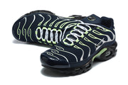 Angled top view of navy Nike Air Max Plus sneakers with white laces and silver and lime-green details.