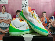 Angled view of white Converse basketball shoes with green and turquoise trim and orange details