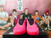 Front view of pink basketball shoes with black laces and tongue details