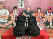 Front view of black and grey Nike sneakers showing the layered toe panels, laces and Nike branding.