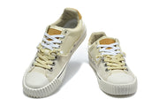 Pair of cream low-top sneakers with contrasting laces and tan tongue accents.
