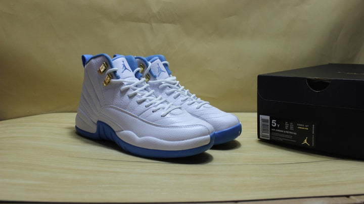 Pair of white and blue high-top Jordan sneakers displayed beside a black shoe box.