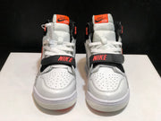 Front view of the pair showing the perforated white toe boxes, white laces, black midfoot straps, and coral branding details.