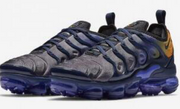 Pair of gray, navy, and orange Nike Air VaporMax Plus sneakers on a plain light background.